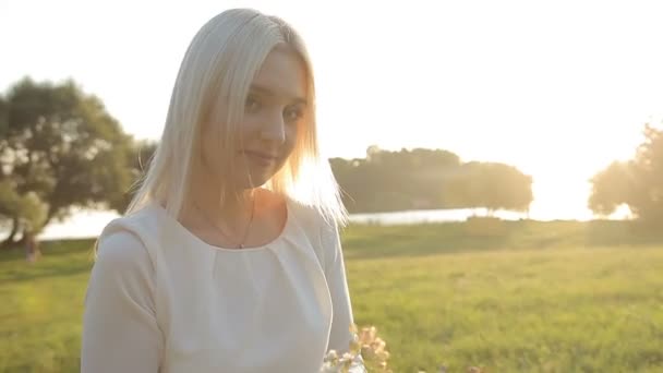 Uma menina está andando no parque ao pôr-do-sol à noite — Vídeo de Stock