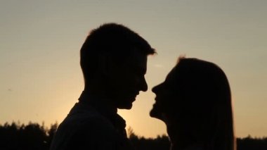 adam ve kız günbatımında öpüşme