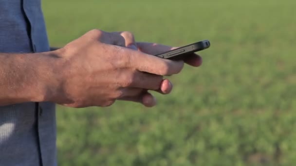 Un jeune homme réécrit un message sur un smartphone — Video