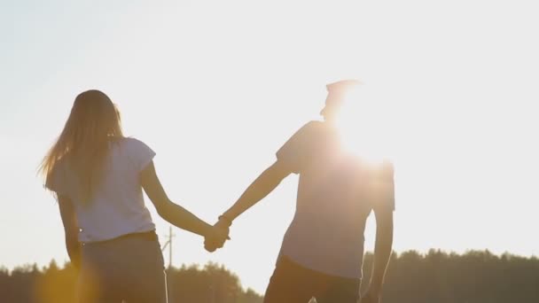 Chico y chica enamorados caminan tomados de la mano — Vídeos de Stock