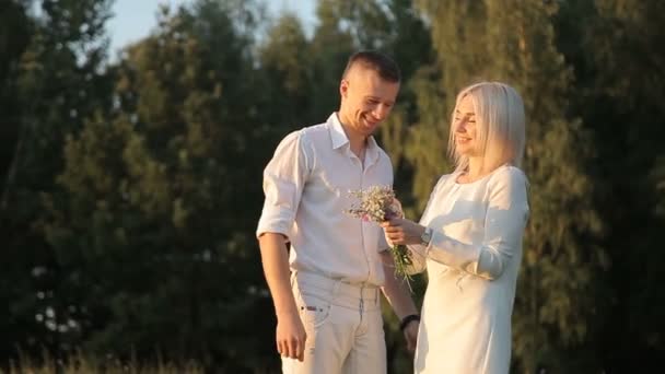 Cara romântico dá uma menina um buquê rústico de flores selvagens — Vídeo de Stock