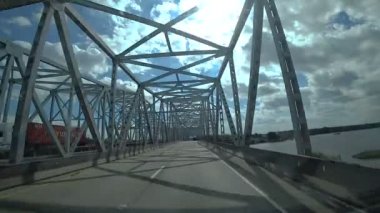 Köprünün diğer tarafında araba kullanıyor