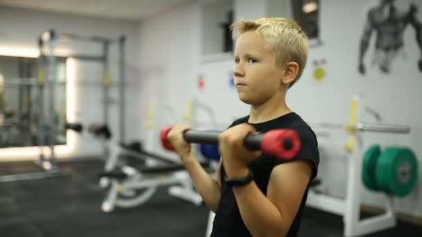 De jongen is training in de sportschool — Stockvideo