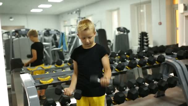 El chico hace ejercicios pesados para los bíceps. . — Vídeos de Stock
