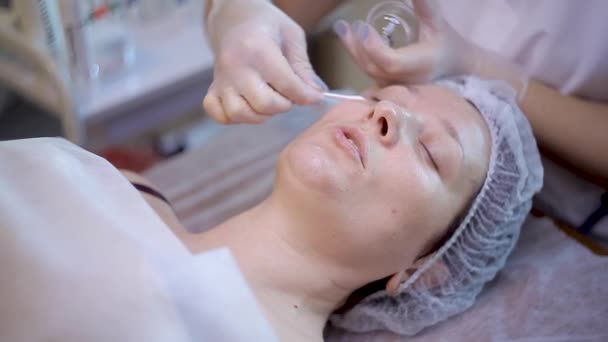 Terapia de spa para mulher jovem recebendo máscara facial no salão de beleza — Vídeo de Stock