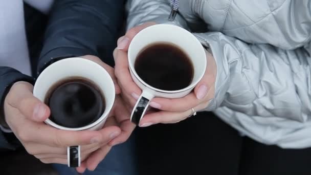 Koppar av kaffe i händerna på en flicka och en kille älskare dricka kaffe — Stockvideo