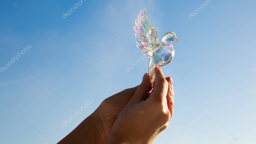 Crystal bird in the hands of a girl.