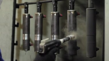 İşçi spreyler boya metal bir parça üzerinde