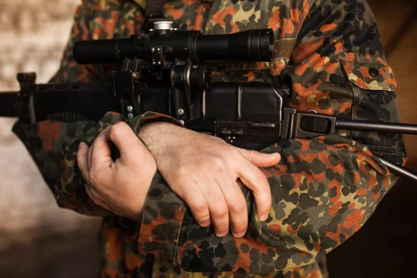 Bir asker elinde bir silah düzenliyor — Stok fotoğraf