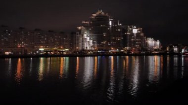Gece şehir ışıkları nehirdeki bir yansıması ile