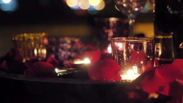 Romantikus este, égő gyertyák, rózsaszirom — Stock videók