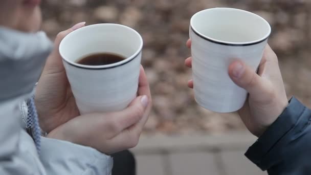 El chico y la chica están bebiendo café en la naturaleza — Vídeo de stock