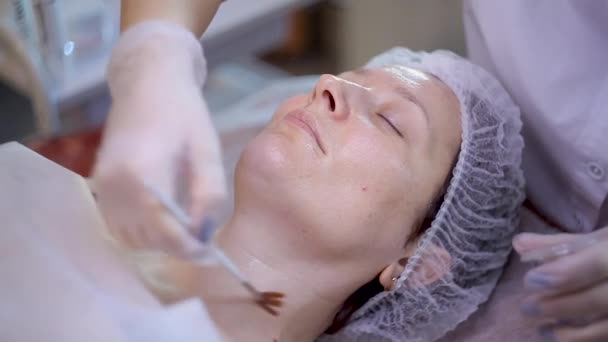 Hermosa mujer con máscara facial en el salón de belleza — Vídeos de Stock