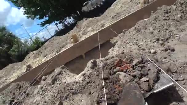 労働者は建設現場でシャベルトレンチを掘る。正確な掘削のためのタイトロープとレイアウト財団 — ストック動画