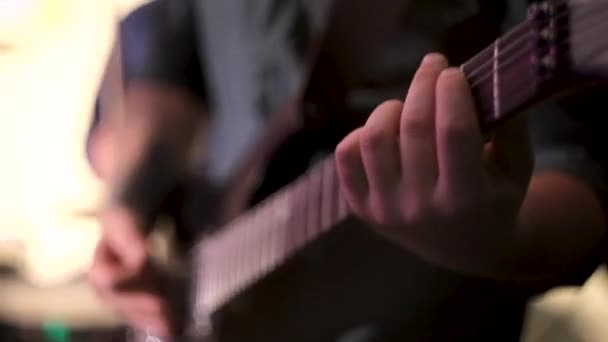 Guitarrista tocando la guitarra en un concierto de pie en el escenario. Concierto banda de rock en el escenario . — Vídeos de Stock