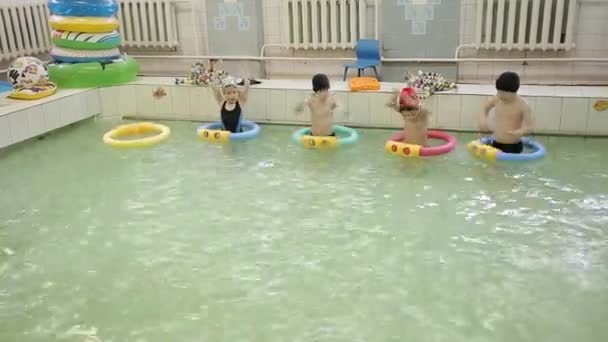 Los niños bucean bajo el agua en la piscina. Natación en la piscina de la escuela . — Vídeos de Stock