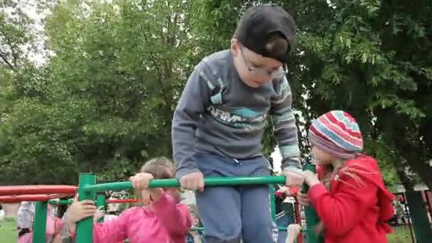 Feliz niños emocionados divirtiéndose y jugando juntos en el patio de recreo en el jardín . — Vídeo de stock