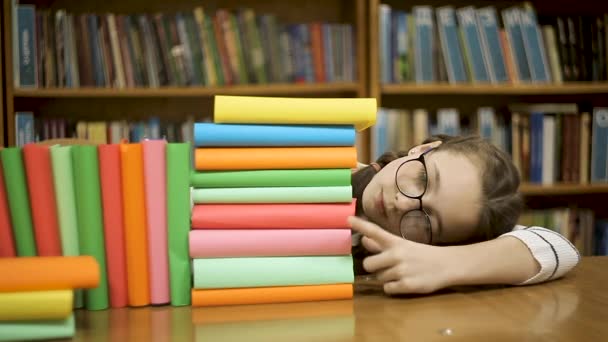 Menina estudante conta o número de livros na biblioteca . — Vídeo de Stock