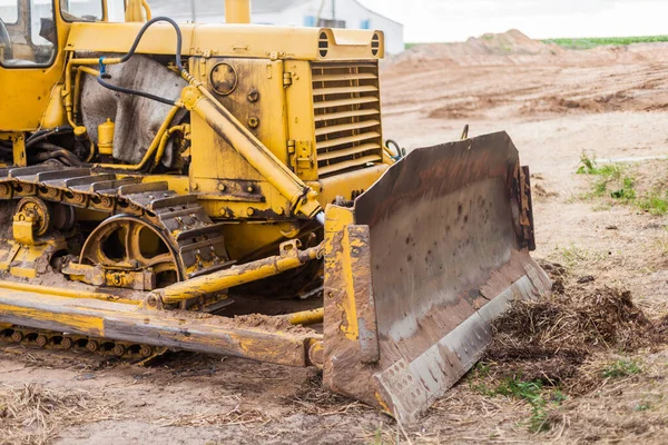 Žlutý traktor na pásce. Detailní záběr transportního buldozeru. Těžké stroje na zemní práce — Stock fotografie