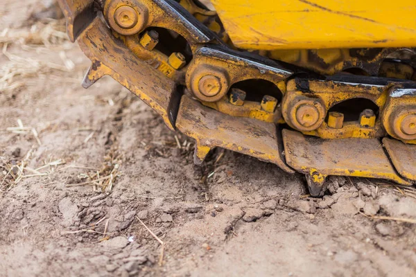 Žlutý traktor na pásce. Detailní záběr transportního buldozeru. Těžké stroje na zemní práce — Stock fotografie