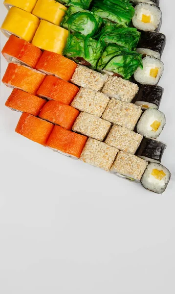 Sushi Set nigiri and sushi rolls.Various sushi and rolls with fish cheese and Chuka salad in chopsticks — Zdjęcie stockowe