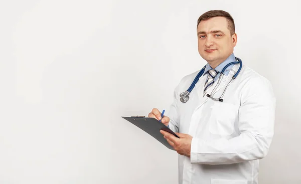 Männerarzt schreibt mit Stift ein Dokument auf Tablet, schreibt Krankengeschichte. — Stockfoto