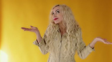 Şok olmuş, şaşkın, Kafkasyalı sarışın kadın omuz silkip omuz silkiyor.