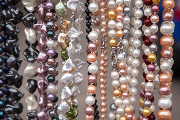 Various colorful beads in the market. Wallpaper background of a colorful necklace made of precious stones and colored beads.