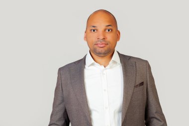 Zeki, kendinden emin, Afro-Amerikalı, gömlekli ve ceketli genç bir adam. Zeki bir görünüş, başarısından emin.