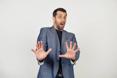 Gülümseyen genç bir işadamı, ceketli sakallı bir adam, şok içinde çığlık çığlığa korku dolu bir ifadeyle korkunç bir şekilde kollarını ileri doğru uzattı. Bir adamın portresi..