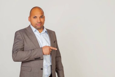 Ceketli, elleri ve parmaklarıyla tiksinti ifadesi gösteren Afrika kökenli Amerikalı bir iş adamı. Uzayı kopyala Gri bir arkaplanda.