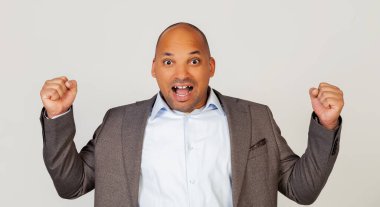 Heyecanlı genç adam Afro-Amerikan iş adamı yüksek sesle bağırıyor ve elleriyle işaret ediyor, neşeli olumlu adam yumruklarını sıkıyor, başarısını kutluyor. Başarı.