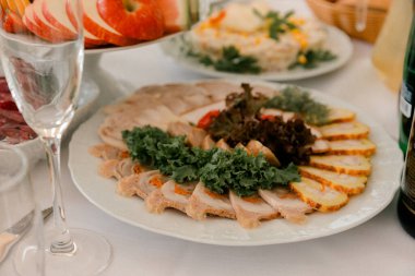 Şenlik sofrasında taze sebzelerle dilimlenmiş et aperatifleri geleneksel mutfağı, bayram yemeklerini, yemek servisini ve yemek atmosferini sembolize ediyor.