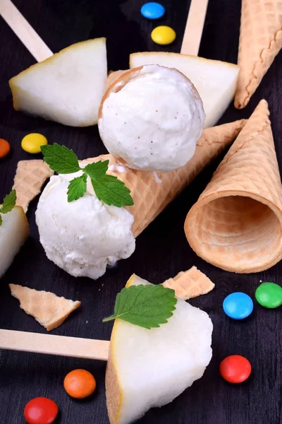 White ice cream in waffle cones, melon popsicles and multicoloured sweets