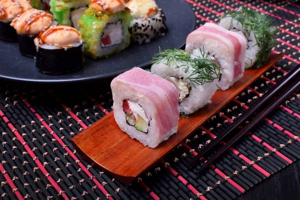 Set of sushi rolls with bacon, dill, chicken, salmon, cheese and rice