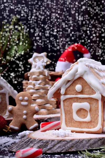 Homemade gingerbread house, spruces and man. Christmas composition