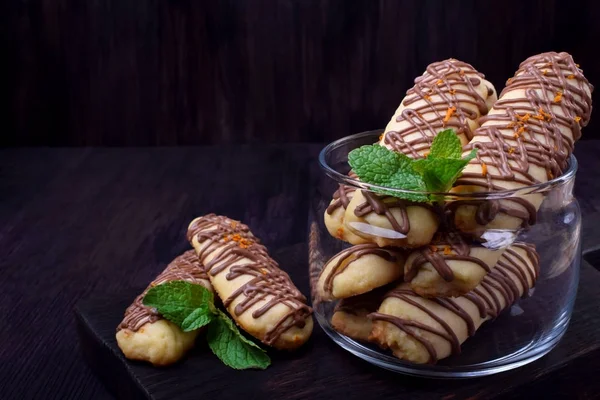 Shortbread cookie sticks with chocolate glazing against the dark background