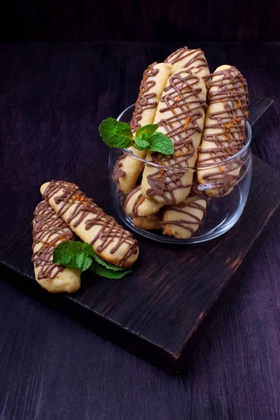 Shortbread cookie sticks with chocolate glazing against the dark background