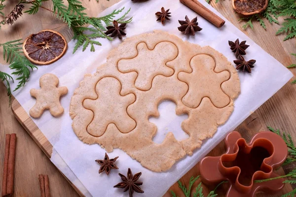 Gingerbread dough for Christmas cookies on a piece of parchment surrounded by spices