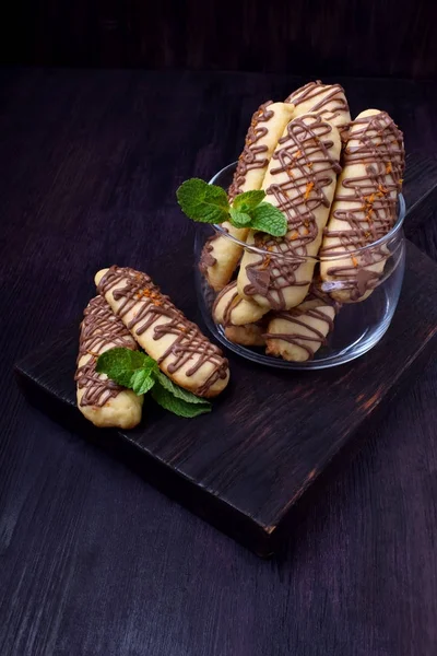 Shortbread cookie sticks with chocolate glazing against the dark background