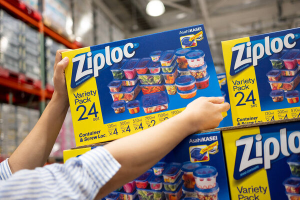 A shopper gets a box of Ziploc Variety Pack of 24 food storage containers from the grocery shelf.