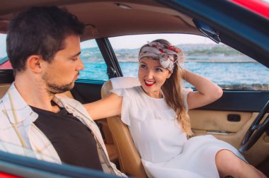 Genç kız beyaz elbise ve kırmızı araba, sahil Malta ön koltuklarda oturan adam