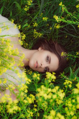 Alandaki sarı çiçek kameraya bakarak döşeme genç güzel kız portresi