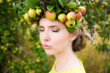 Çelenk elma dan baş ve kapalı olan kadın yapma öpücük dudaklar tarafından gözleri.