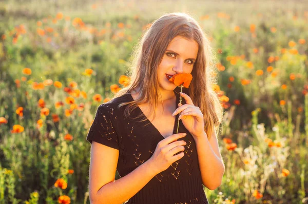 美しい少女フィールドのスニッフィングでケシの花 — ストック写真