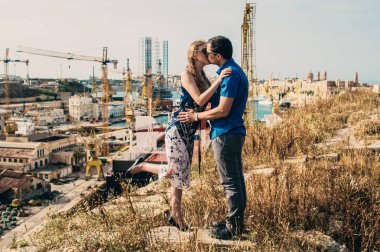 Adam ve kadın öpüşme, vinçler ve Dock arka planda, Malta