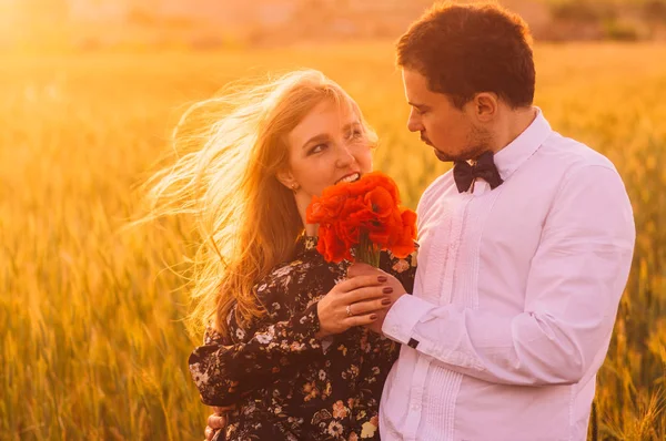 男人给妇女花束罂粟在麦田在黄昏 马耳他 — 图库照片
