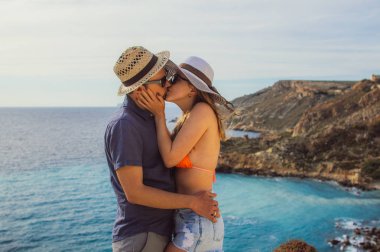 Çift kucaklama ve bir gün sahilde güzel öpüşme için deniz manzaralı