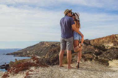Çift kucaklama ve bir gün sahilde güzel öpüşme için deniz manzaralı