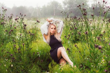 Eller başının üstünde, thistle ilk planı üzerinde papatya alanında dans genç kız portresi